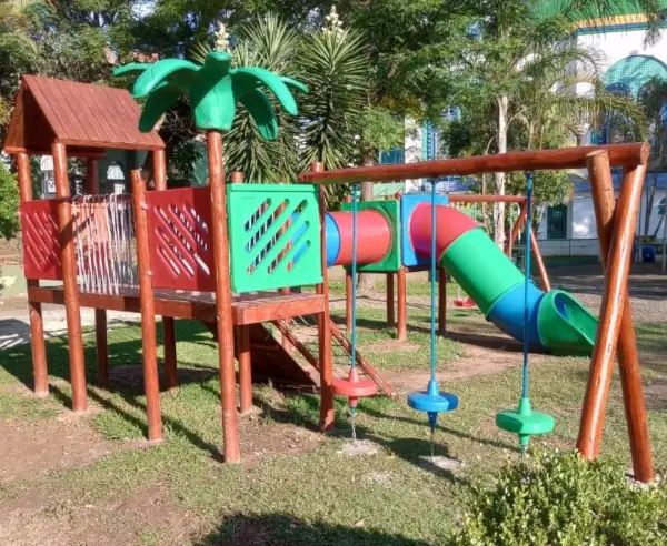 Parquinho de madeira e plástico esportando decoração de coqueiro e estação de equilíbrio, tobogã, demais acessórios